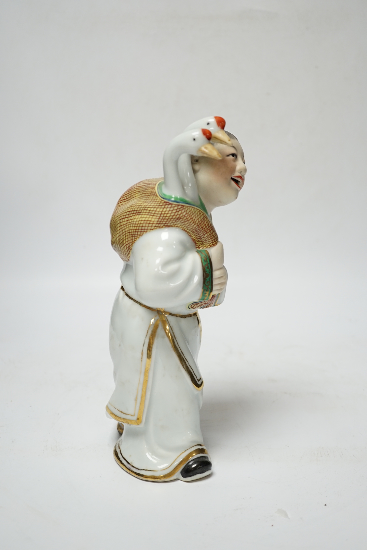A Chinese enamelled porcelain figure of a man with two geese, 25cm high